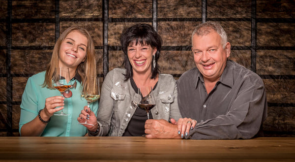 three people enjoying wine