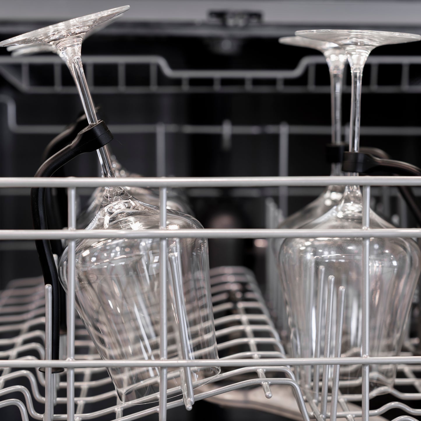 Wine glasses secured in dishwasher rack with tethers